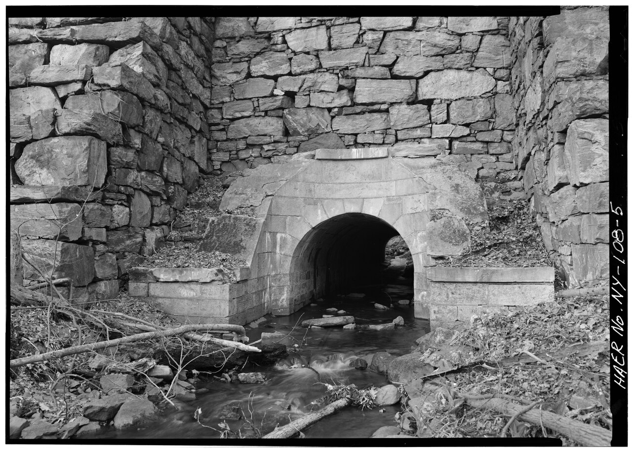 GENERAL VIEW SHOWING CULVERT. BUTTRESSING ON LEFT AND RIGHT WAS ADDED AT A LATER DATE. - Old Croton Aqueduct, Indian Creek Culvert, Reservoir and Quaker Bridge Roads, Crotonville HAER NY,60-CROTV,1A-5.tif