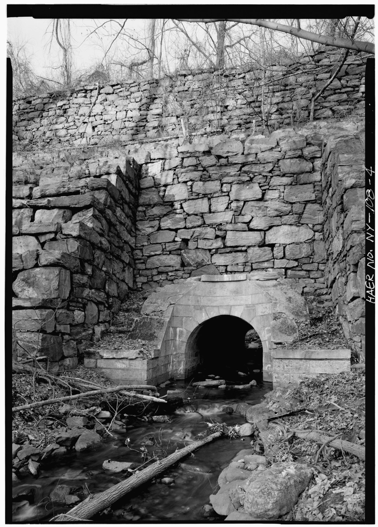 GENERAL VIEW SHOWING INDIAN CREEK (FOREGROUND) AND CULVERT. AQUEDUCT PASSES ABOVE CULVERT. - Old Croton Aqueduct, Indian Creek Culvert, Reservoir and Quaker Bridge Roads, HAER NY,60-CROTV,1A-4.tif